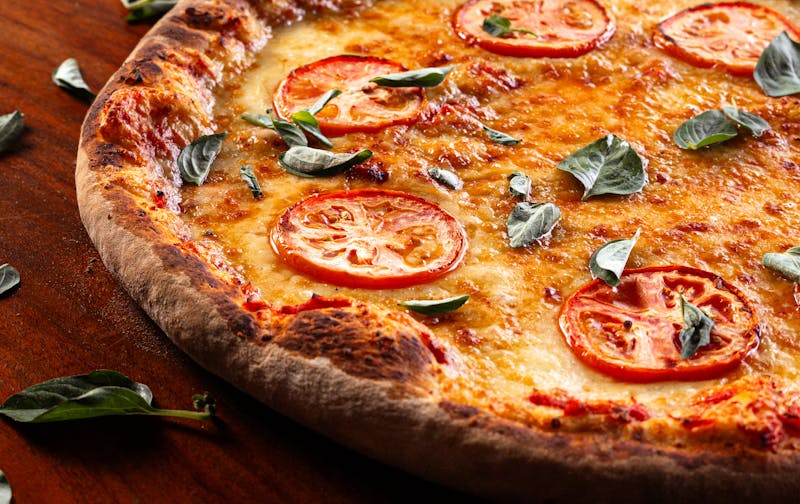 Margherita thin crust pizza with fresh basil and tomatoes